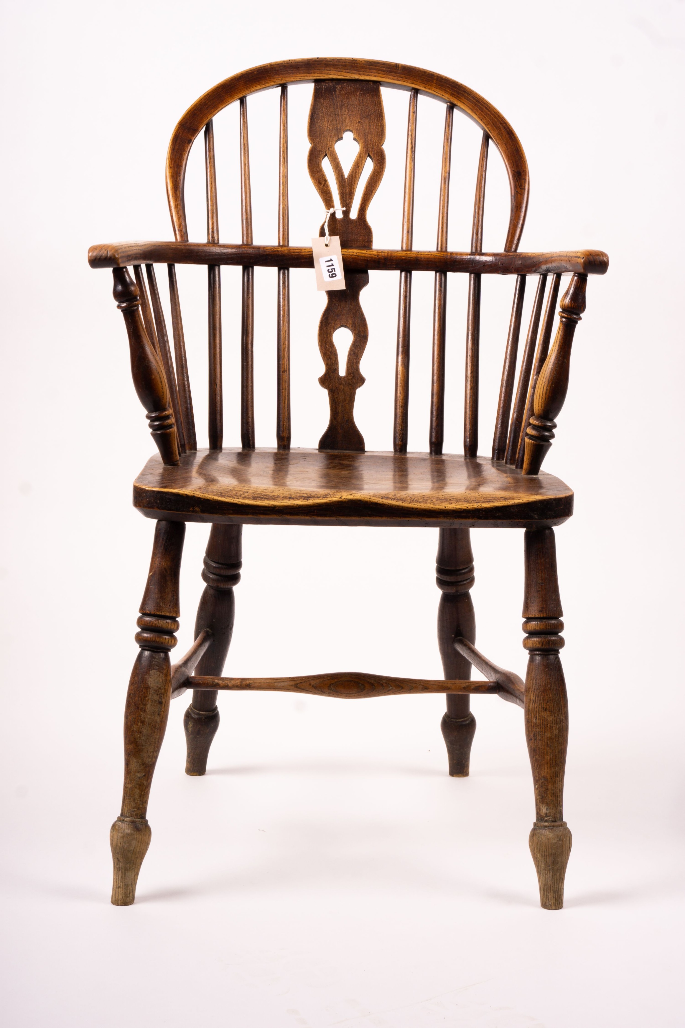 A mid 19th century ash and elm Derbyshire area Windsor elbow chair, together with a 19th century yew and elm Windsor wheel back chair with crinoline stretcher